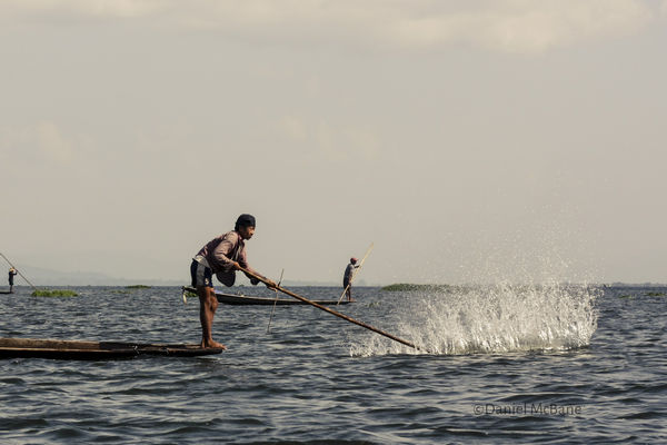 Local hitting water with paddle on Inle Lake