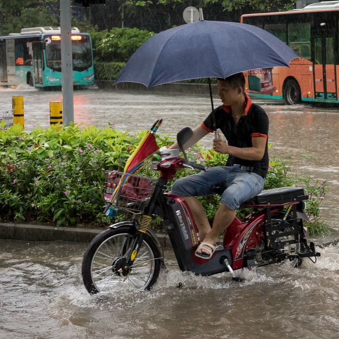 Man on electric bike in Shenzhen with umbrella