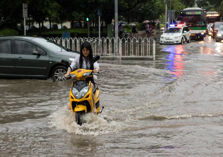 Chinese girl on motorbike in flood